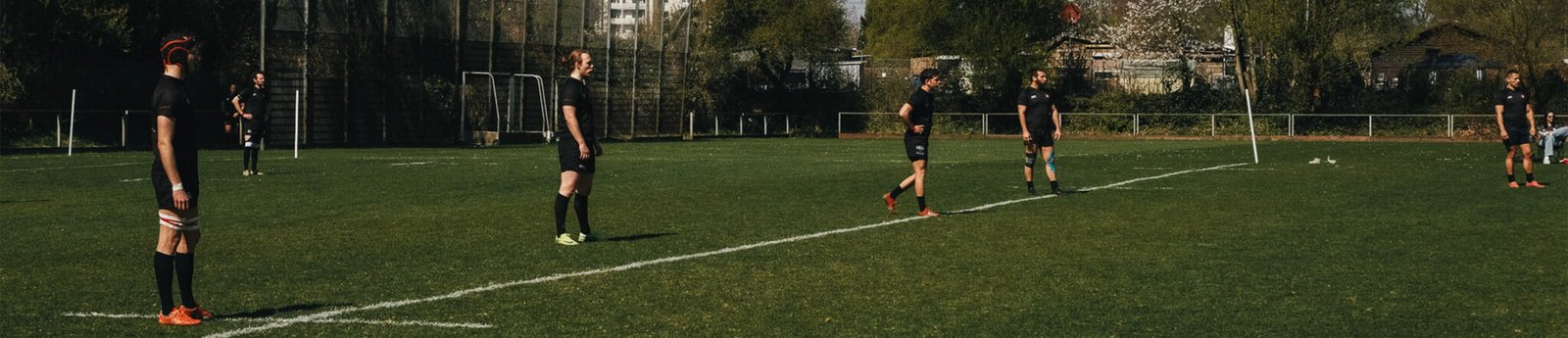 Hamburger Exiles rugby players standing in position on the field