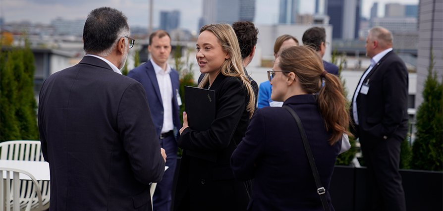 Professionals networking on a rooftop terrace in an urban setting